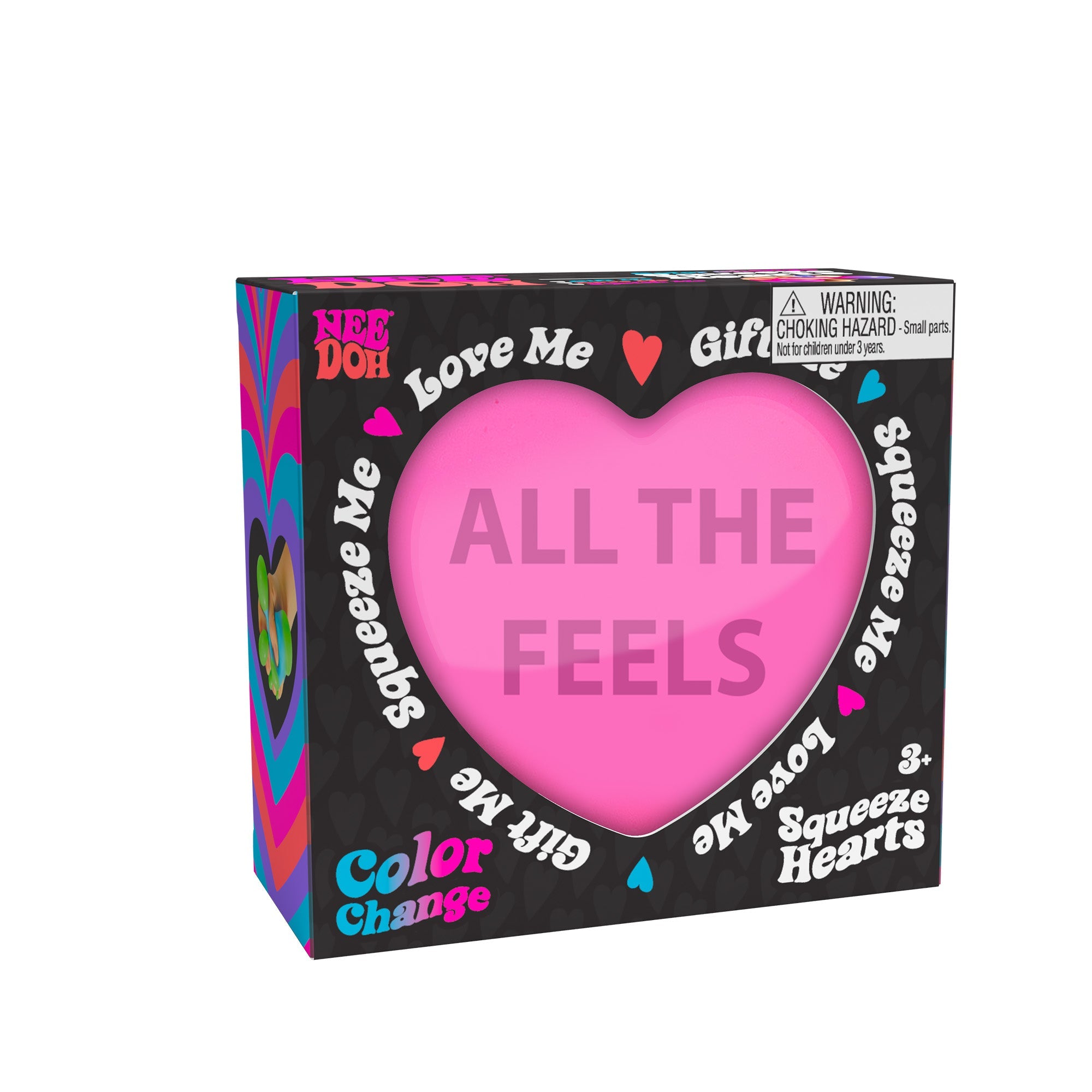 A boxed Nee Doh Color Change Squeeze Heart E1 toy. The packaging is predominantly black with colorful accents, featuring phrases like "ALL THE FEELS," "Squeeze Me," "Love Me," and "Gift Me." The box also includes a choking hazard warning for small parts.